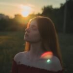 Woman standing in a sunset field with eyes closed, reflecting peace and growth — a visual of how to heal from toxic relationship
